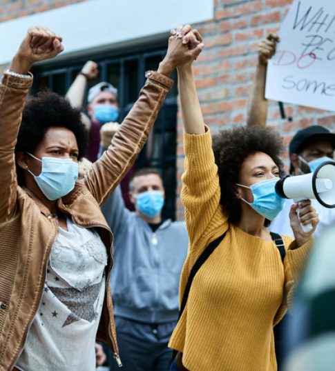 multiethnic-crowd-people-with-protective-face-masks-protesting-city-streets-focus-is-african-american-women-holding-hands (1)
